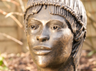 A highly decorated African female head inspired by the wonderful photograph book 'The People of Kau' by Leni Riefenstahl.They belong to the Nuba Tribe of the Sudan, a wild and passionate people whose primitive life style is fast disappearing. Suitable for a garden setting and cast in frost proof resin. 
Patinated in a dark bronze with a black hardwood base.